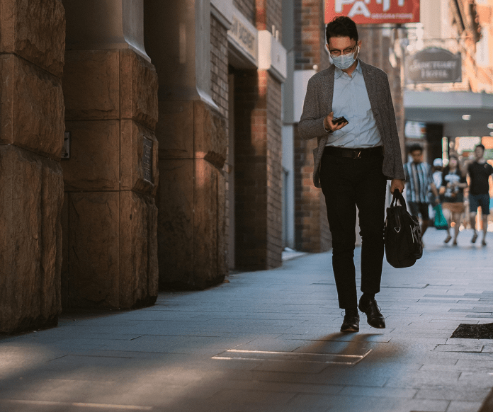 an office worker wearing a facemask while outdoors