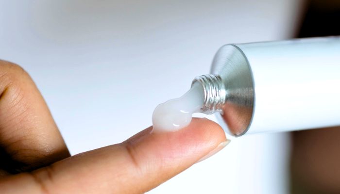 woman-applying-cream-to-fingers
